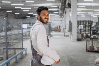 Makine operatörü. Fabrikada sanayi işçisi. Beyaz şapkalı genç teknisyen..