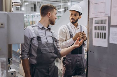 Deneyimli mühendisler üretim fabrikasında modern endüstriyel üretim makinesine hizmet veriyorlar.