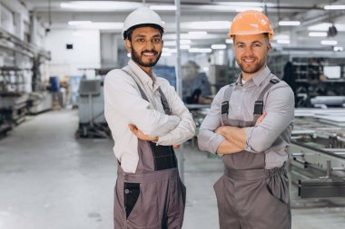 PVC pencere ve kapı üretiminin arka planında çalışan iki uluslararası erkek işçi.