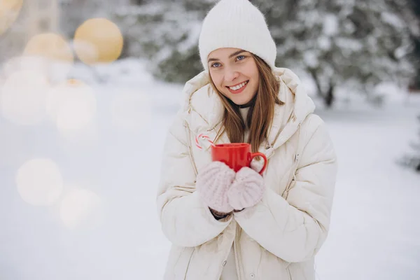 在冬天的公园里 穿着针织手套 拿着加糖的热咖啡的可爱的快乐女人 — 图库照片
