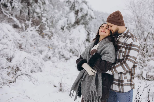 stock image Portrait of a young happy and loving couple having fun in a snowy forest