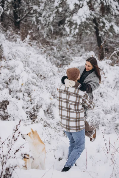 快乐的年轻夫妇 冬天和下雪天在森林里和秋田的狗在一起 — 图库照片
