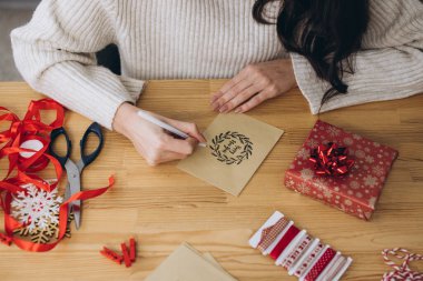 Kadınların elleri yeni yıl ve Noel için toplanıyor ve tebrik kartı imzalıyor.