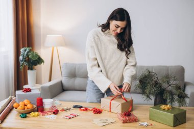 Noel hediye kutularını paketleyen kadın, kapat. Dekor elemanları ve ögeleri olan beyaz masada hazırlıksız hediyeler Noel veya Yeni Yıl Kutu Paketi.