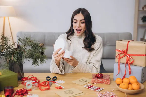 女性は 感情とクリスマスギフトボックスを包むか 包み込む 閉じます 装飾要素および項目が付いているテーブルの準備ができていない提示 クリスマスか新年のDiyのパッキング コンセプト — ストック写真