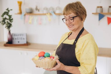 Mutlu Paskalyalar! Sevimli emekli yaşlı kadın evdeki mutfağa paskalya yumurtası boyamış. DIY paskalya yumurtası yapıyor.