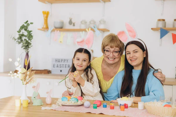 复活节快乐 三代女人 快乐的妈妈带着女儿和奶奶画着五彩斑斓的彩蛋 在厨房里玩得很开心 — 图库照片