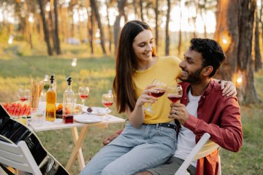 Mutlu çok ırklı çift arkadaşlarıyla bir partide şarap içiyor.
