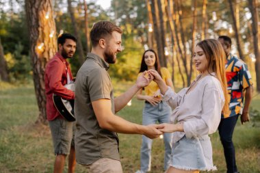 Arkadaşlarının arka planında dans eden güzel bir çift.