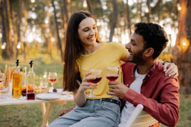 Mutlu çok ırklı çift arkadaşlarıyla bir partide şarap içiyor.