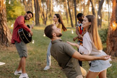Arkadaşlarının arka planında dans eden güzel bir çift.