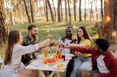 Gitar çalan, şarkı söyleyen, yemek yiyen ve ormanda parti yaparken şarap içen çok ırklı arkadaş grubuyla tanışmak.