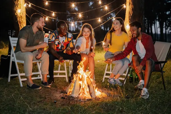Group Multiracial Restful Friends Roasting Marshmallows While Sitting Bonfire — Stock Photo, Image