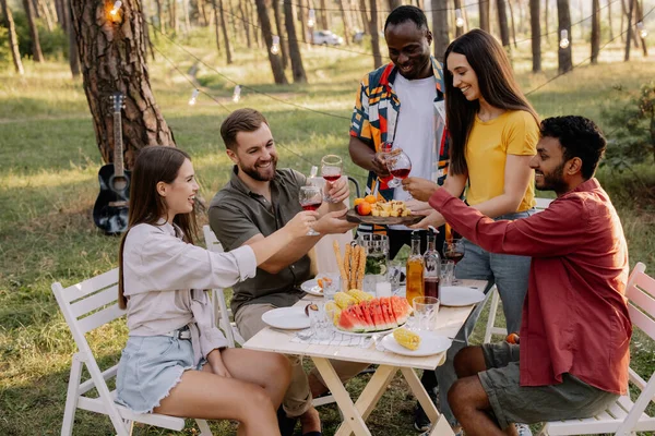 Encontro Grupo Multirracial Amigos Jantando Bebendo Vinho Durante Festa Floresta — Fotografia de Stock