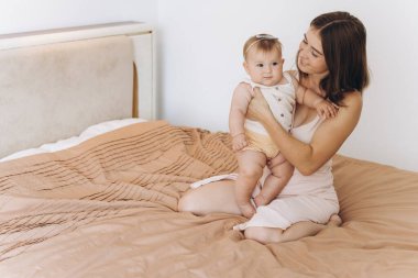 Mutlu anne ve güzel küçük kızı yataktaki yataktalar.