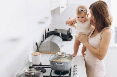 Bir anne ve küçük kızı mutfakta yemek hazırlıyorlar.