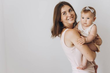 Beyaz arka planda sevimli küçük kızı olan mutlu bir anne.