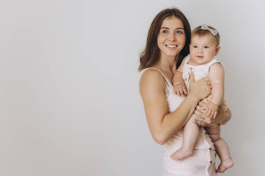 Beyaz arka planda sevimli küçük kızı olan mutlu bir anne.