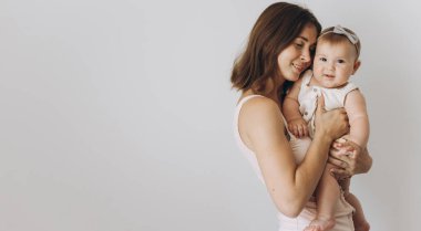 Beyaz arka planda sevimli küçük kızı olan mutlu bir anne.