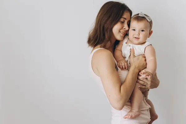 白い背景に彼女の愛らしい赤ん坊の女の子と幸せな若い母 — ストック写真