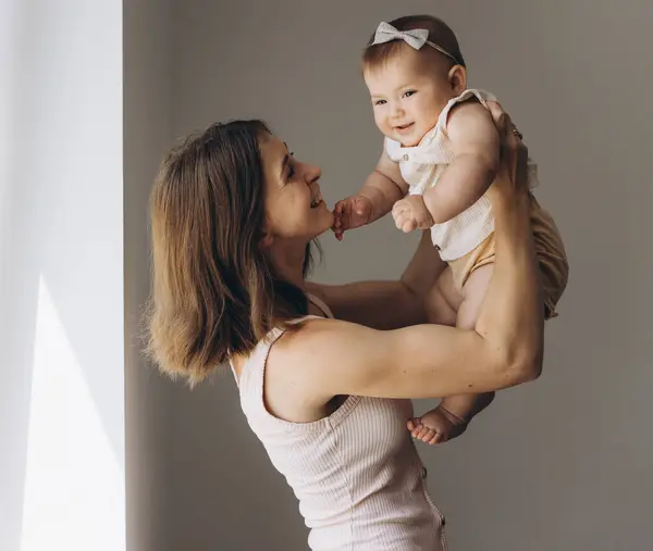Szczęśliwa Matka Uroczą Córeczką Podczas Podnoszenia Powietrzu Białym Tle — Zdjęcie stockowe