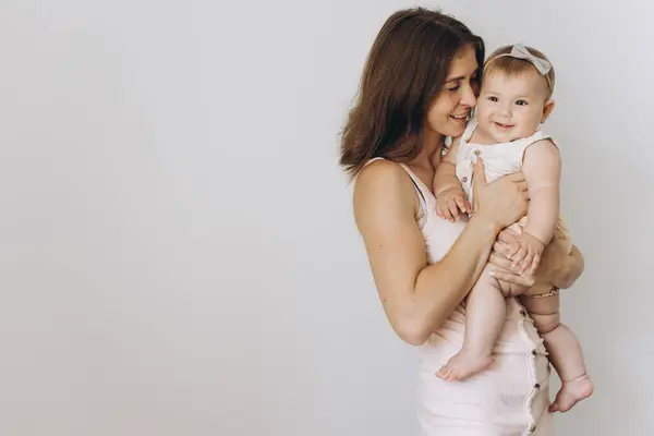 白い背景に彼女の愛らしい赤ん坊の女の子と幸せな若い母 — ストック写真