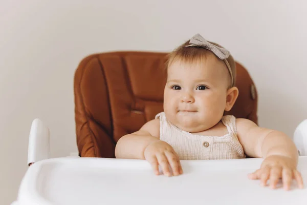自宅でキッチンで高い椅子に座っている幸せな小さな赤ん坊の少女 — ストック写真