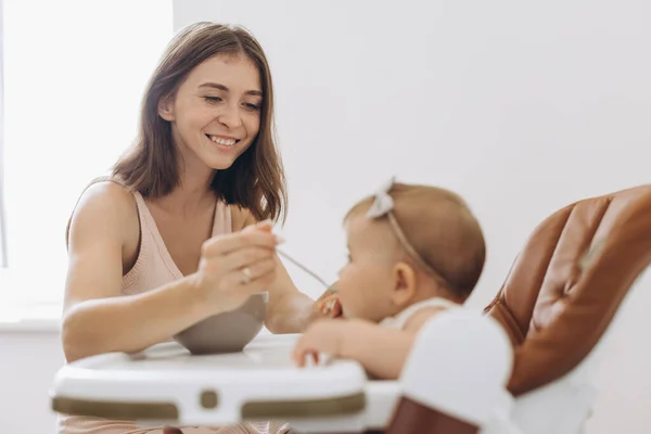 Mother Feeding Healthy Food Her Adorable Little Daughter Sitting High — Stock Photo, Image