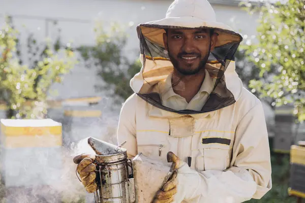 Szczęśliwy Uśmiechnięty Indyjski Mężczyzna Pszczelarz Palenie Pszczół Miodnych Pszczelarz Pasiece — Zdjęcie stockowe