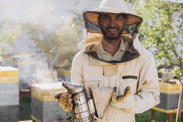 Szczęśliwy Uśmiechnięty Indyjski Mężczyzna Pszczelarz Palenie Pszczół Miodnych Pszczelarz Pasiece — Zdjęcie stockowe