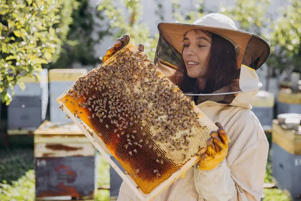 Счастливая Женщина Пчеловод Защитном Костюме Держит Пчелиную Раму Пчелами Пасеке — стоковое фото