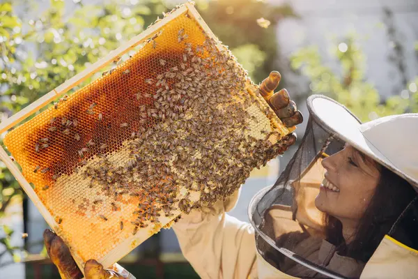 Χαρούμενη Χαμογελαστή Γυναίκα Μελισσοκόμος Στολή Στέκεται Στο Μελισσοκομείο Και Κρατώντας — Φωτογραφία Αρχείου