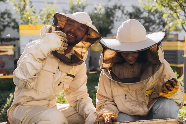 Пара Счастливых Улыбающихся Пчеловодов Работающих Пчеловодческими Инструментами Возле Пчелиного Улья — стоковое фото