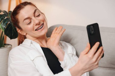 Video çağrısında dişlerinde diş teli olan olgun bir kadının portresi