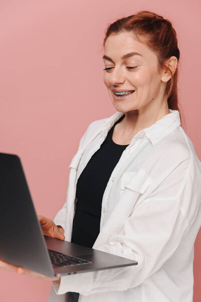 Зрелая женщина с брекетами, консультирующаяся с ортодонтом по видеосвязи