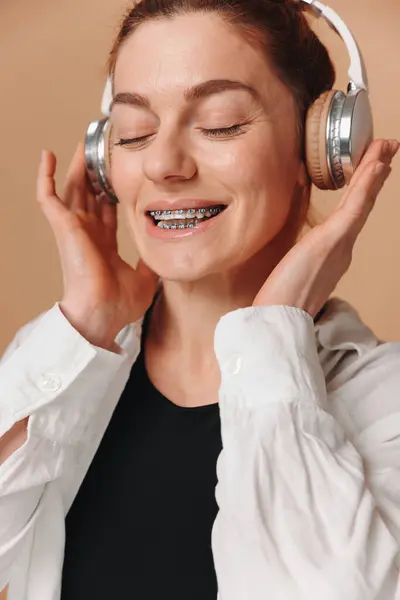 Moderne Frau Lächelt Mit Zahnspange Auf Den Zähnen Und Hört — Stockfoto