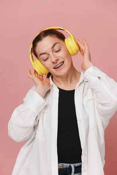 Σύγχρονη Γυναίκα Χαμογελώντας Τιράντες Στα Δόντια Της Και Ακούγοντας Μουσική Royalty Free Εικόνες Αρχείου