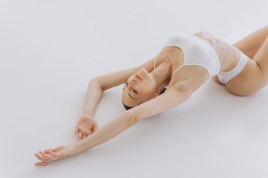 Vücut Güzeli, Beyaz İç Çamaşırlı Sıska Kadın Sırtüstü Uzanıyor, Mutlu Rüya Gören Kız Kopya Alanlı Beyaz Arkaplanda İzole Edildi,