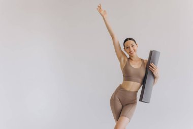 Beyaz arka planda yoga minderi tutan genç kadın panoramik afiş, spor, fitness, meditasyon, yoga dengesi, farkındalık, egzersiz, hobi, sağlıklı yaşam tarzı konsepti