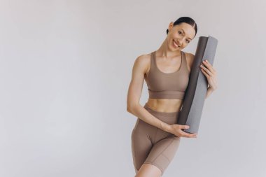 Beyaz arka planda yoga minderi tutan genç kadın panoramik afiş, spor, fitness, meditasyon, yoga dengesi, farkındalık, egzersiz, hobi, sağlıklı yaşam tarzı konsepti