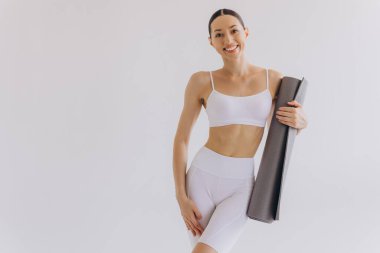 Beyaz arka planda yoga minderi tutan genç kadın panoramik afiş, spor, fitness, meditasyon, yoga dengesi, farkındalık, egzersiz, hobi, sağlıklı yaşam tarzı konsepti