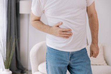 Evde sindirim sorunları, karaciğer ve safra kesesi sorunları ve bağırsak ağrısı çeken yaşlı bir adam var.