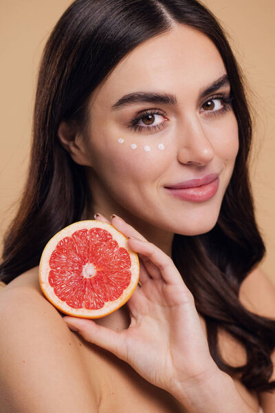 Eye Skin Care Woman. Beautiful Young Woman Holding Grapefruit Applying Eye Cream Drops On Skin Under Eyes. Antiage Treatment Concept. High Quality