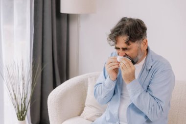 Yaşlı bir adamın mendile hapşırması, soğuk algınlığı veya alerjiden rahatsızlık duyması, mevsimsel alerjiler, virüs, grip ve hasta sağlığı, sağlık durumu, kıdemli bakım ve solunum için tıbbi tedavi