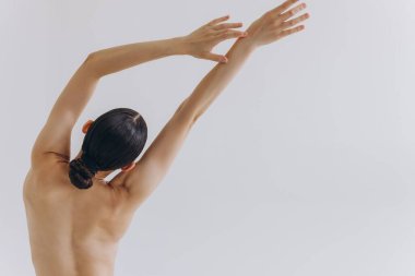 Arkadan kesilmiş, ince vücutlu, mükemmel ciltli, çıplak sütyen giyen seksi kadın beyaz arka planda izole edilmiş kalçalara el ele tutuşuyor. Yaşam tarzı diyet konsepti