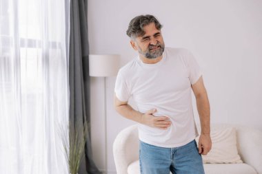 Evde sindirim sorunları, karaciğer ve safra kesesi sorunları ve bağırsak ağrısı çeken yaşlı bir adam var.
