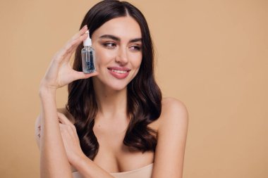 Bej arka planda Serum Bırakan Kadın. Pipette 'ten Serum Kolajeni Nemlendirici kullanan Avrupalı Kız. Yakın plan. Pozitif Gülen Güzel Kadın Portresi. Yüz Cildi Bakımı Konsepti