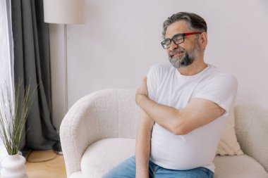 Artrit belirtileri. Evde omuz ağrısı çeken yaşlı sakallı adam.