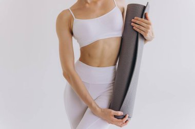 Beyaz arka plan, panoramik pankart, spor, spor, fitness, meditasyon, yoga dengesi, farkındalık, egzersiz, sağlıklı yaşam tarzı konsepti üzerinde izole edilmiş yoga minderi taşıyan yakın plan fotoğraf.