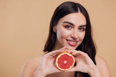 Göz Cildi Bakıcı Kadın. Greyfurt Tutan Güzel Genç Kadın Göz Altındaki Cilde Göz Kremi Döküyor. Antiyaj Tedavisi Konsepti. Yüksek Kalite